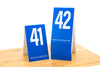 Tall blue tent style table numbers in number sequence 41-60. Table numbers are ideal for any restaurant or food service setting. www.citygrafx.com.