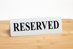 Reserved tent style tabletop signs. Reserved signs are printed with black text on a white background.